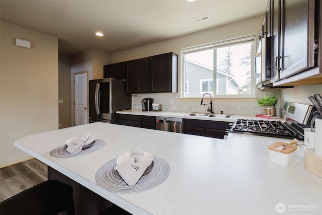 2450 Zeeden Way, Bremerton, WA 98310 - kitchen with a sink, appliances with stainless steel finishes, light countertops, a kitchen bar, and recessed lighting