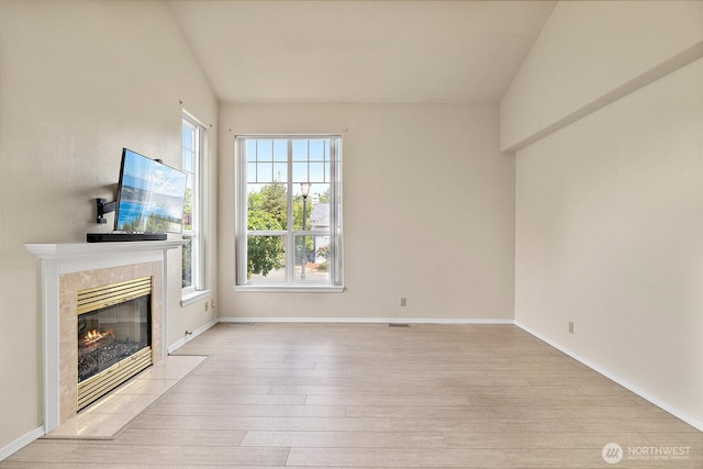 12015 SE 312th Pl Unit 7D, Auburn, WA 98092 - unfurnished living room with a premium fireplace, light wood-style flooring, and baseboards