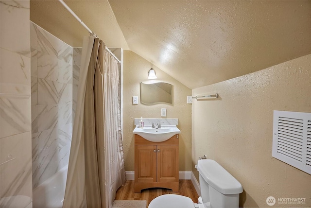 1027 S 60th St, Tacoma, WA 98408 - bathroom featuring vaulted ceiling, vanity, toilet, wood finished floors, and a textured wall