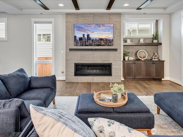 11550 174th Ave NE, Redmond, WA 98052 - living area with wood finished floors, beam ceiling, a tiled fireplace, healthy amount of natural light, and recessed lighting