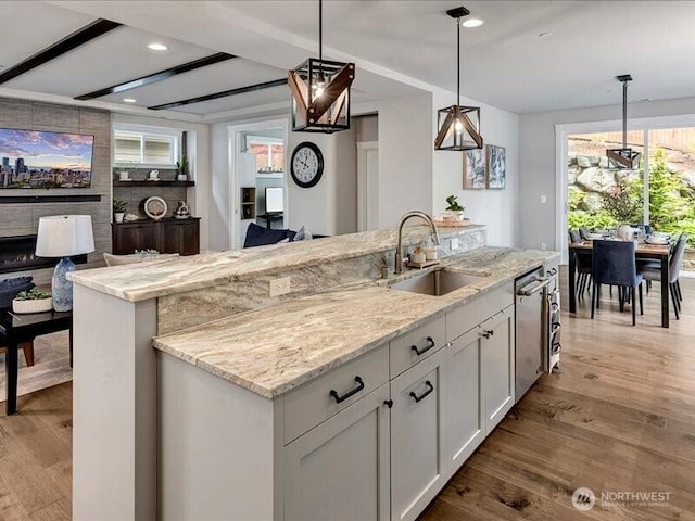 11550 174th Ave NE, Redmond, WA 98052 - kitchen featuring a sink, stainless steel dishwasher, light stone counters, white cabinetry, and hanging light fixtures