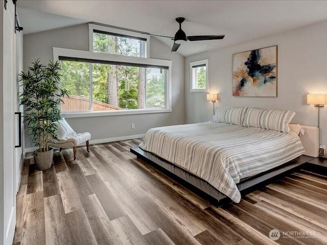 11550 174th Ave NE, Redmond, WA 98052 - bedroom featuring lofted ceiling, wood finished floors, baseboards, ceiling fan, and a barn door