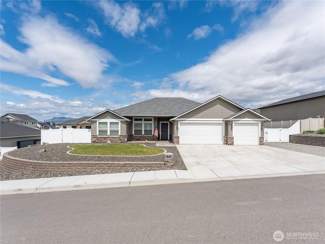 2611 Paisley St SE, East Wenatchee, WA 98802 - view of front facade featuring a garage, driveway, and stone siding