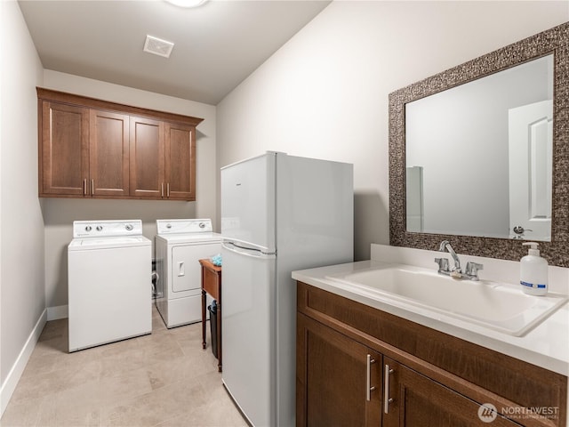2611 Paisley St SE, East Wenatchee, WA 98802 - laundry area featuring a sink, washing machine and dryer, baseboards, and light tile patterned flooring