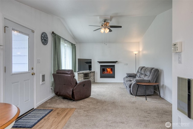 184 Frigate St NW, Ocean Shores, WA 98569 - living area featuring lofted ceiling, a warm lit fireplace, ceiling fan, and baseboards