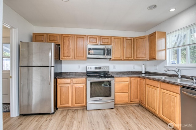 184 Frigate St NW, Ocean Shores, WA 98569 - kitchen featuring stainless steel appliances, a sink, light wood-style floors, dark stone counters, and recessed lighting