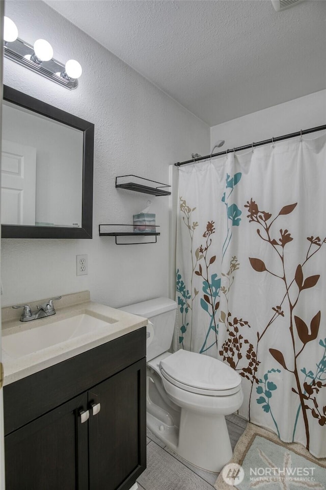 184 Frigate St NW, Ocean Shores, WA 98569 - full bathroom featuring a textured ceiling, toilet, vanity, curtained shower, and tile patterned floors