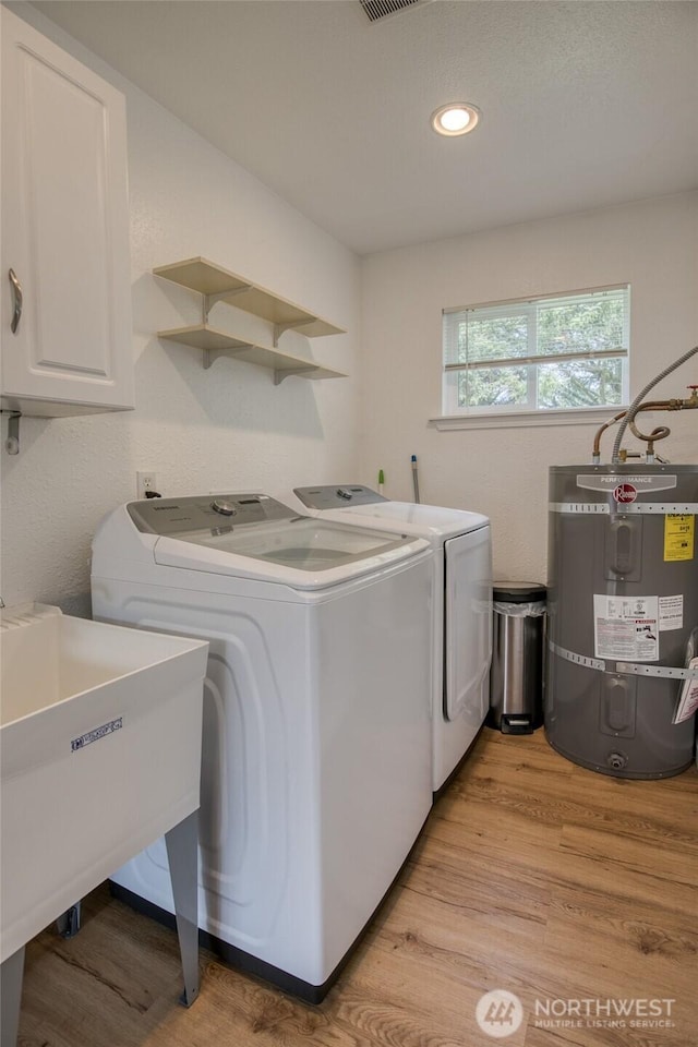 184 Frigate St NW, Ocean Shores, WA 98569 - clothes washing area featuring strapped water heater, separate washer and dryer, cabinet space, light wood-style floors, and recessed lighting