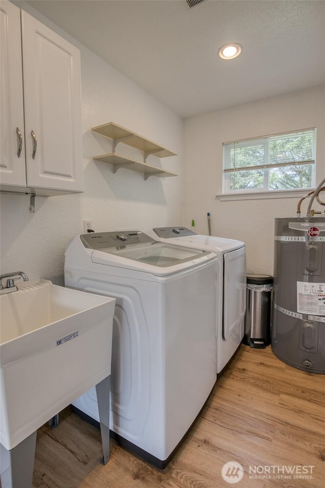 184 Frigate St NW, Ocean Shores, WA 98569 - washroom featuring strapped water heater, separate washer and dryer, cabinet space, light wood-style flooring, and recessed lighting