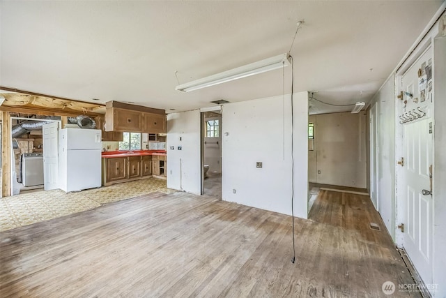 3122 Oas Dr W, University Place, WA 98466 - kitchen with freestanding refrigerator, washer / clothes dryer, light wood-style flooring, and brown cabinetry
