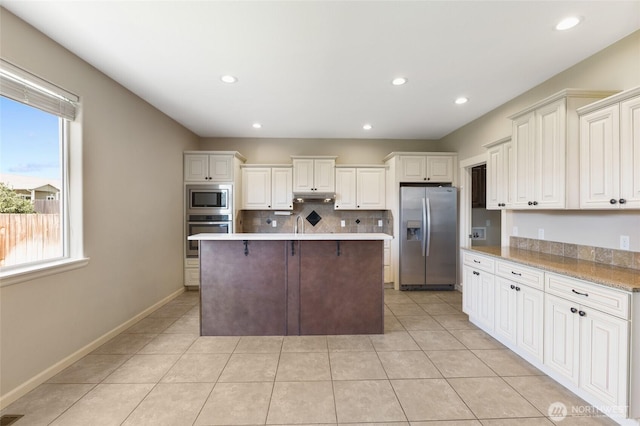 546 S Driftwood Ln, Moses Lake, WA 98837 - kitchen featuring appliances with stainless steel finishes, under cabinet range hood, light tile patterned flooring, a kitchen island, and recessed lighting