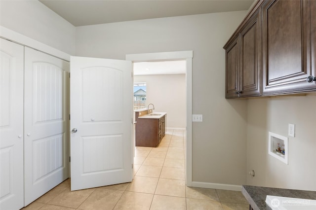 546 S Driftwood Ln, Moses Lake, WA 98837 - clothes washing area featuring cabinet space, washer hookup, light tile patterned floors, and baseboards
