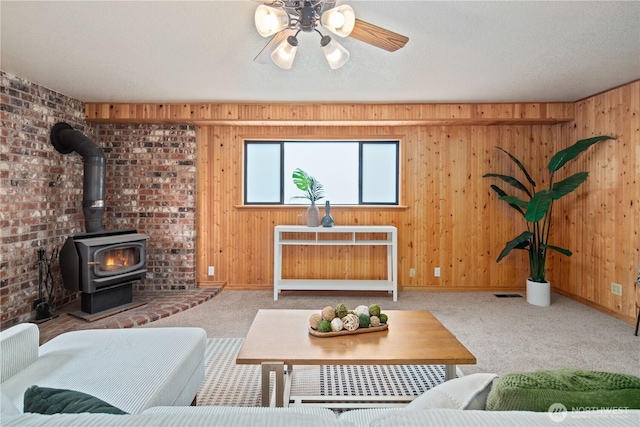 16044 33rd Ave NE, Lake Forest Park, WA 98155 - living room featuring carpet flooring, wooden walls, a wood stove, ceiling fan, and baseboards