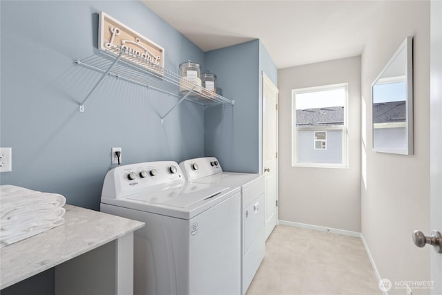 washroom featuring washer and clothes dryer, baseboards, and light carpet