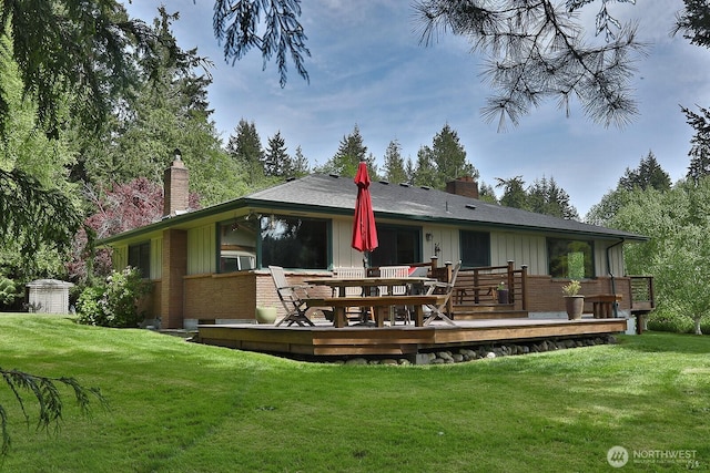 5066 Bayview Rd, Langley, WA 98260 - rear view of house featuring board and batten siding, a chimney, brick siding, and a lawn