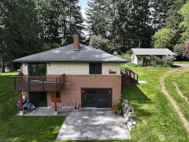 5066 Bayview Rd, Langley, WA 98260 - back of property with a patio, brick siding, a chimney, a lawn, and a shingled roof
