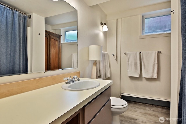 5066 Bayview Rd, Langley, WA 98260 - bathroom with a baseboard radiator, wood finished floors, toilet, vanity, and curtained shower
