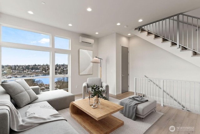 living room featuring a wall mounted air conditioner, light wood-type flooring, and recessed lighting