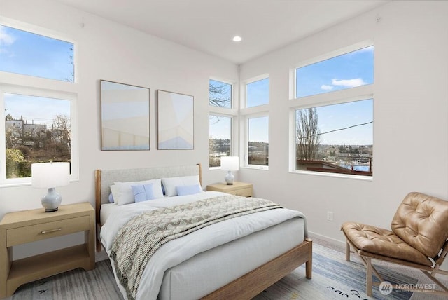 bedroom featuring multiple windows, baseboards, recessed lighting, and wood finished floors