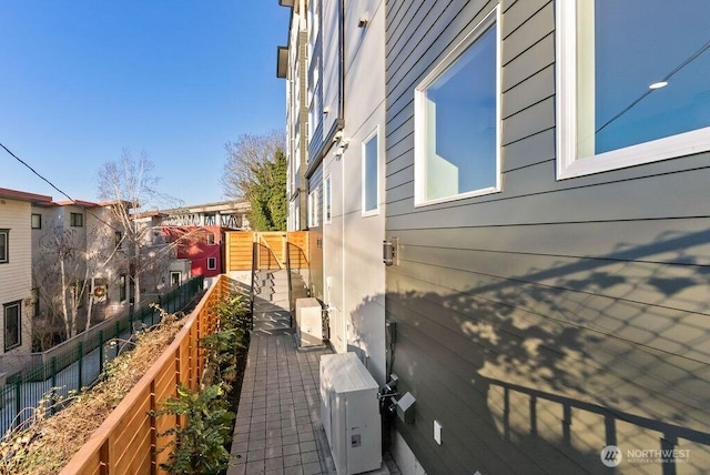 view of side of home with fence and a cooling unit