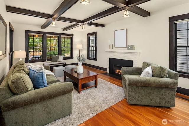 3227 37th Ave S, Seattle, WA 98144 - living area featuring wood-type flooring, a brick fireplace, beamed ceiling, baseboards, and a ceiling fan