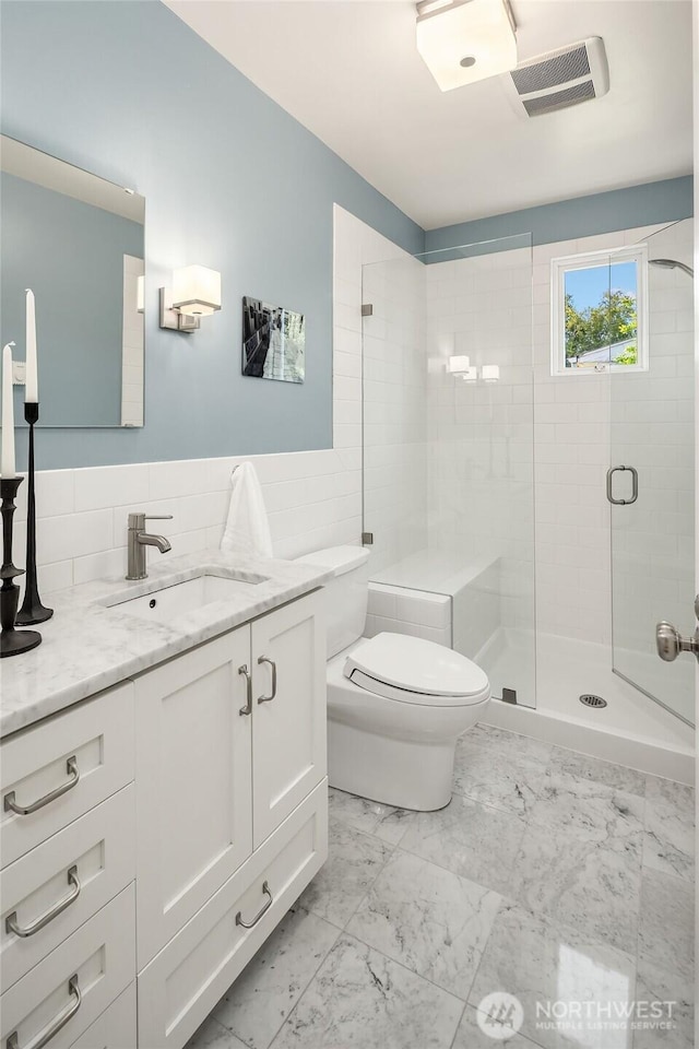 3227 37th Ave S, Seattle, WA 98144 - bathroom with vanity, marble look tiles, tile walls, toilet, and a stall shower