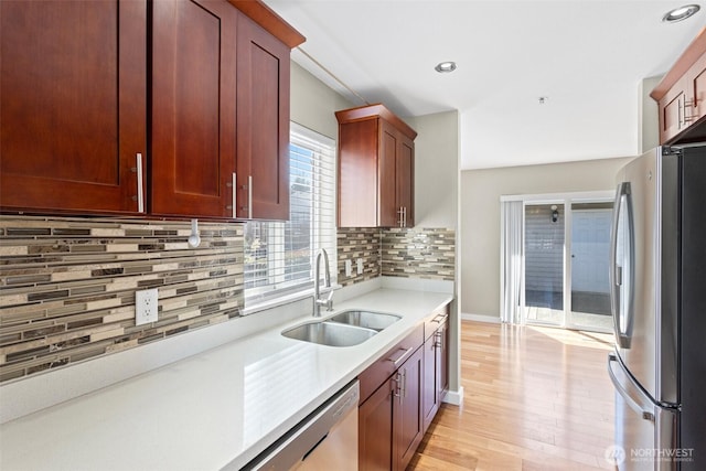 901 E Marine View Dr Unit 201, Everett, WA 98201 - kitchen with appliances with stainless steel finishes, a sink, light countertops, decorative backsplash, and light wood-type flooring