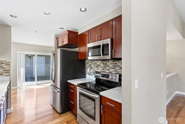 901 E Marine View Dr Unit 201, Everett, WA 98201 - kitchen with stainless steel appliances, backsplash, light wood-style floors, light countertops, and baseboards