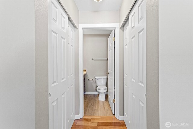 901 E Marine View Dr Unit 201, Everett, WA 98201 - bathroom featuring wood finished floors, toilet, and baseboards