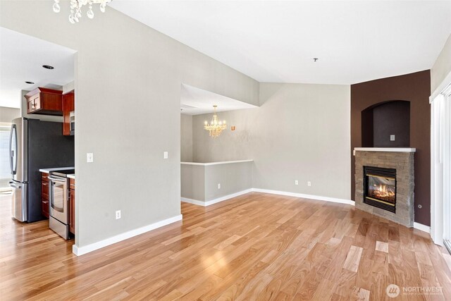 901 E Marine View Dr Unit 201, Everett, WA 98201 - unfurnished living room featuring a chandelier, light wood-type flooring, a fireplace, and baseboards