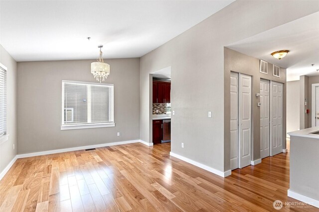 901 E Marine View Dr Unit 201, Everett, WA 98201 - unfurnished dining area with a chandelier, light wood-style flooring, and baseboards