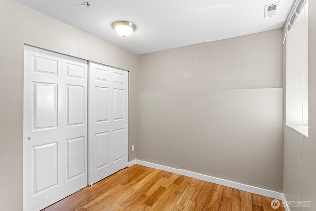 901 E Marine View Dr Unit 201, Everett, WA 98201 - unfurnished bedroom featuring light wood finished floors, a closet, and baseboards