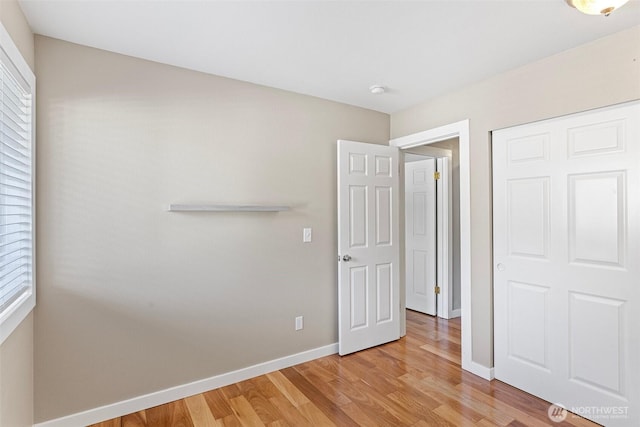 901 E Marine View Dr Unit 201, Everett, WA 98201 - unfurnished bedroom featuring light wood-style flooring, baseboards, and a closet