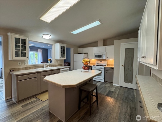 21 Cedar Hill Ln, Sequim, WA 98382 - kitchen featuring white appliances, tile counters, a kitchen island, dark wood finished floors, and glass insert cabinets