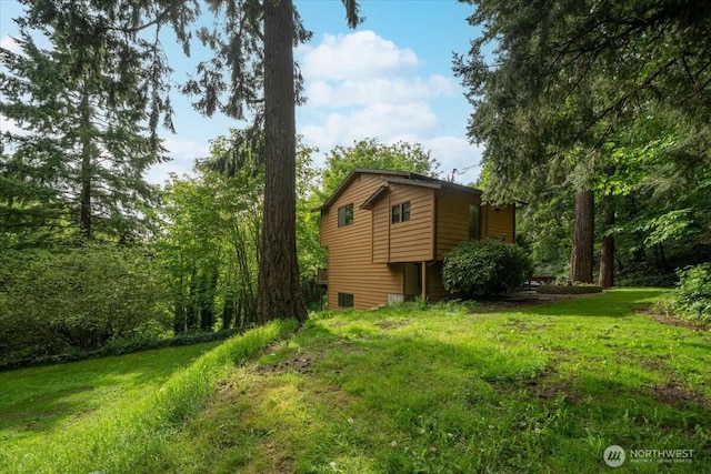view of side of home with a yard