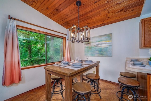 dining room featuring lofted ceiling, wood ceiling, a chandelier, and baseboards