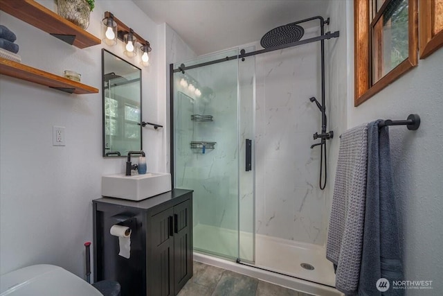 full bath with a marble finish shower, vanity, and toilet