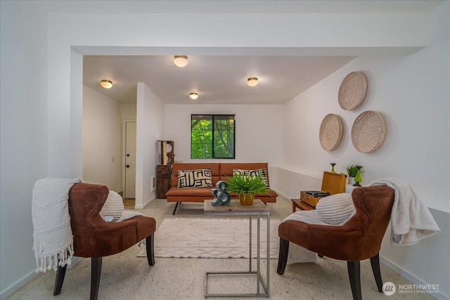 sitting room featuring baseboards and light carpet
