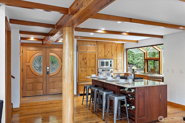 8526 E Mercer Way, Mercer Island, WA 98040 - kitchen with stainless steel appliances, light wood finished floors, beam ceiling, a kitchen bar, and a kitchen island