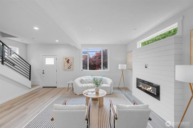 118 16th Ave, Seattle, WA 98122 - living room featuring wood finished floors, a glass covered fireplace, baseboards, stairs, and recessed lighting