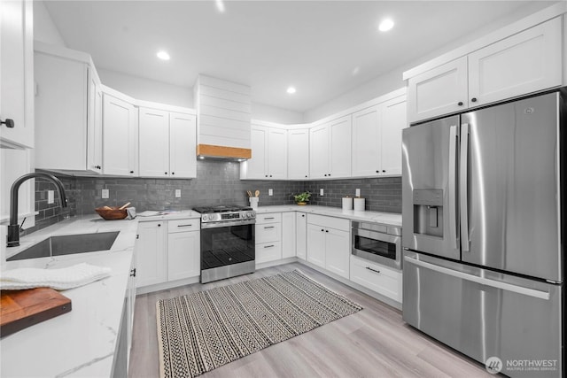 118 16th Ave, Seattle, WA 98122 - kitchen featuring appliances with stainless steel finishes, a sink, light stone counters, white cabinetry, and recessed lighting