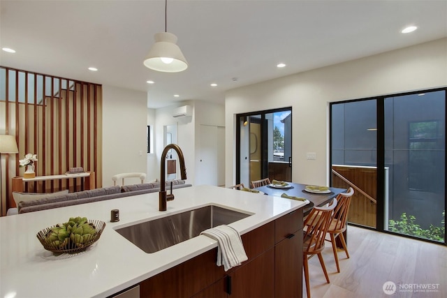 3816B 36th Ave W, Seattle, WA 98199 - kitchen featuring a sink, a wall mounted air conditioner, light countertops, modern cabinets, and recessed lighting