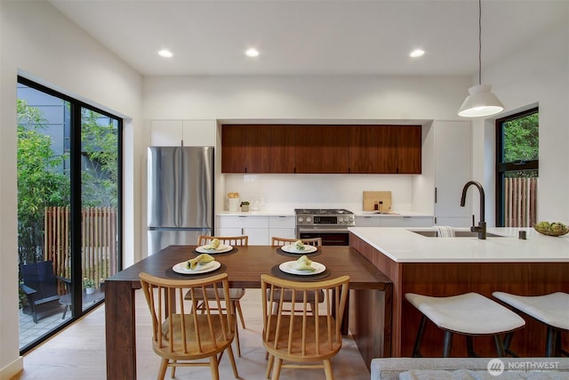 3816B 36th Ave W, Seattle, WA 98199 - kitchen featuring a sink, stainless steel appliances, modern cabinets, light countertops, and pendant lighting