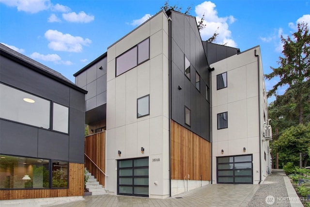 3816B 36th Ave W, Seattle, WA 98199 - view of building exterior featuring an attached garage, decorative driveway, and stairs