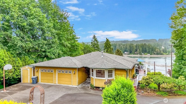 7509 145th St NW, Gig Harbor, WA 98329 - view of front of property with a garage, a forest view, asphalt driveway, and a water view