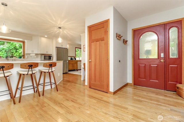7509 145th St NW, Gig Harbor, WA 98329 - foyer entrance with plenty of natural light, light wood-type flooring, and baseboards