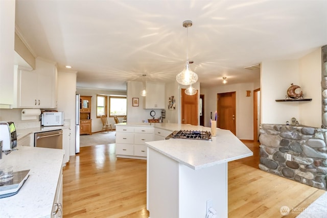 7509 145th St NW, Gig Harbor, WA 98329 - kitchen featuring light wood-style floors, stainless steel appliances, white cabinetry, and hanging light fixtures