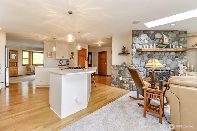 7509 145th St NW, Gig Harbor, WA 98329 - kitchen with appliances with stainless steel finishes, light wood finished floors, light countertops, white cabinetry, and a kitchen island