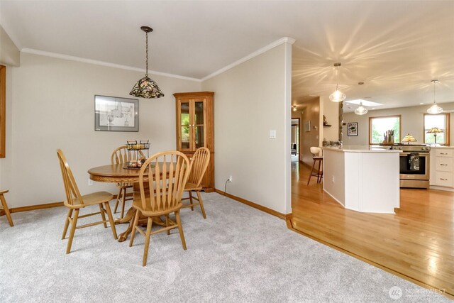 7509 145th St NW, Gig Harbor, WA 98329 - dining area featuring crown molding, baseboards, light carpet, and light wood-style flooring
