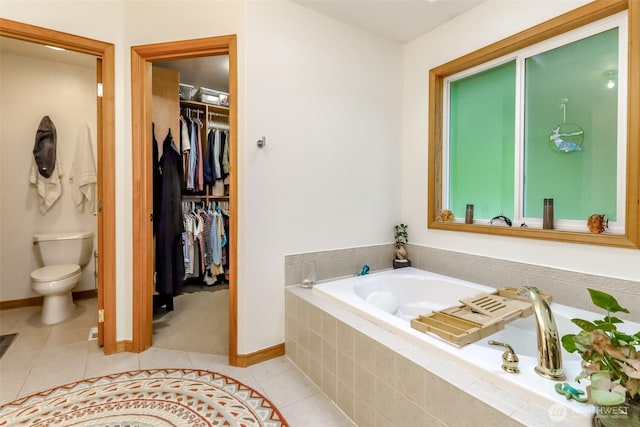 7509 145th St NW, Gig Harbor, WA 98329 - full bathroom featuring tile patterned floors, a garden tub, toilet, baseboards, and a spacious closet